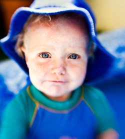 Baby in blue sun suit and hat